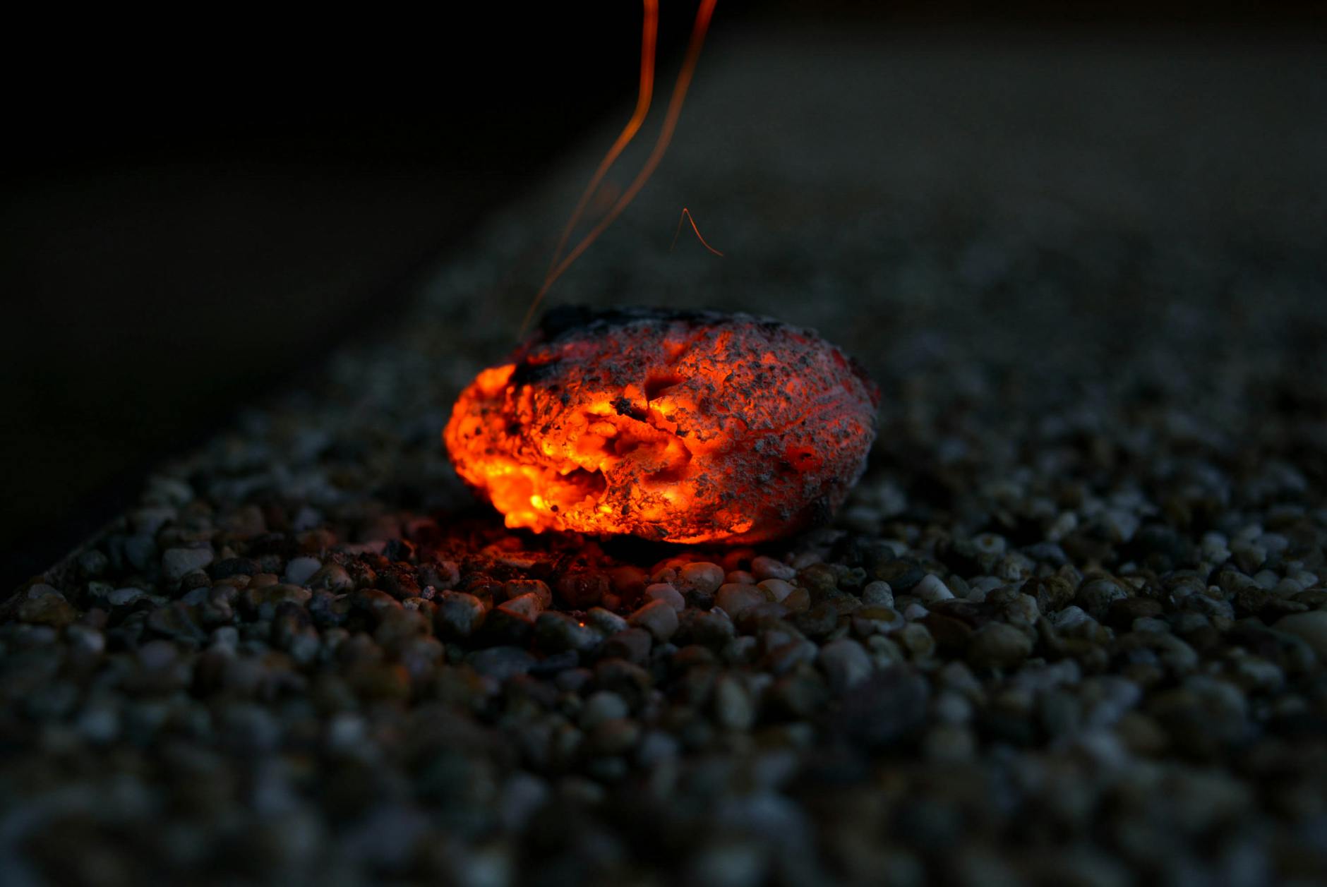 Żarzące się kawałki węgla na drobnych kamieniach