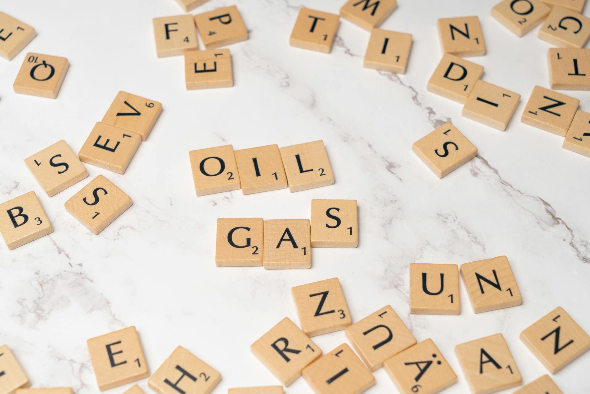 Kostki Scrabble z napisami oil i gas na marmurowym tle