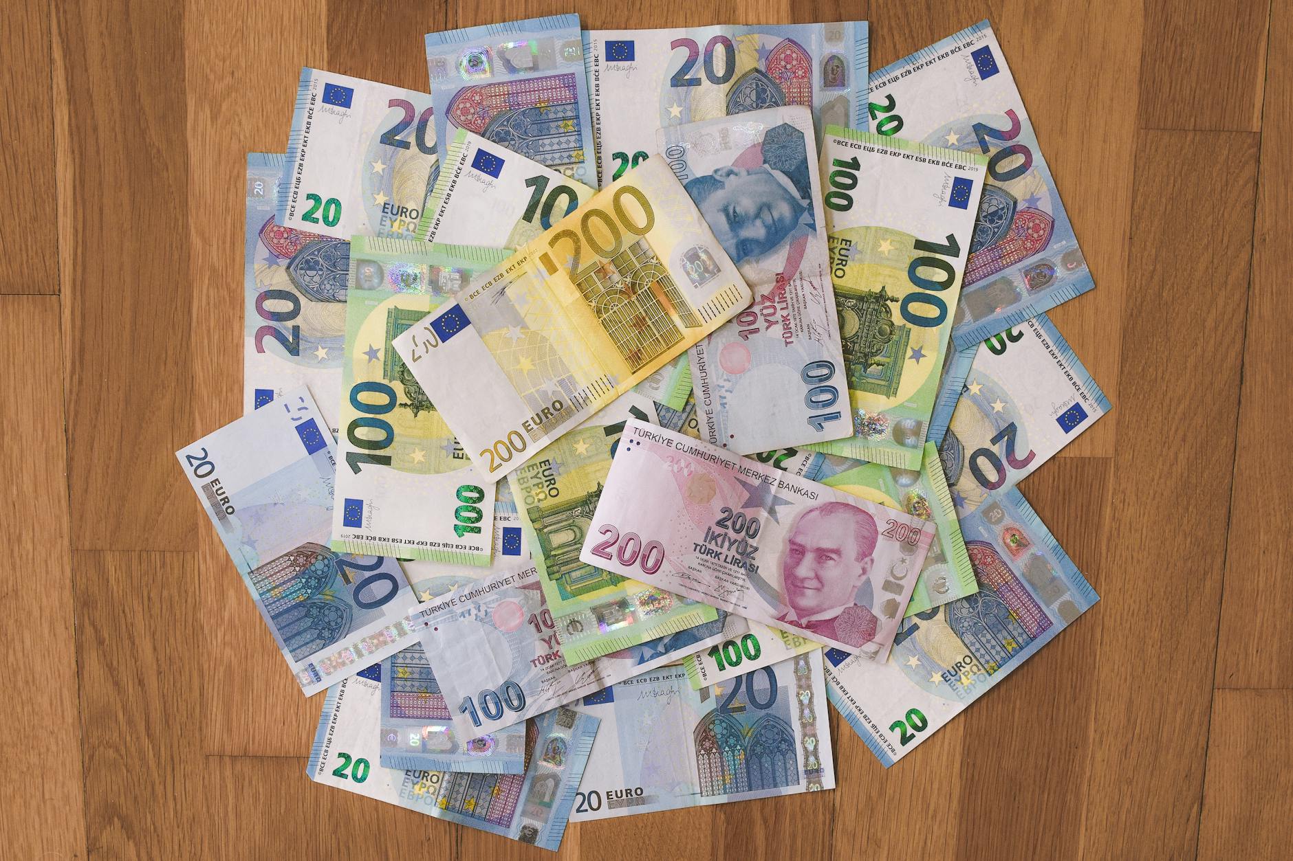 Banknoty euro i lir tureckich rozrzucone na drewnianym blacie