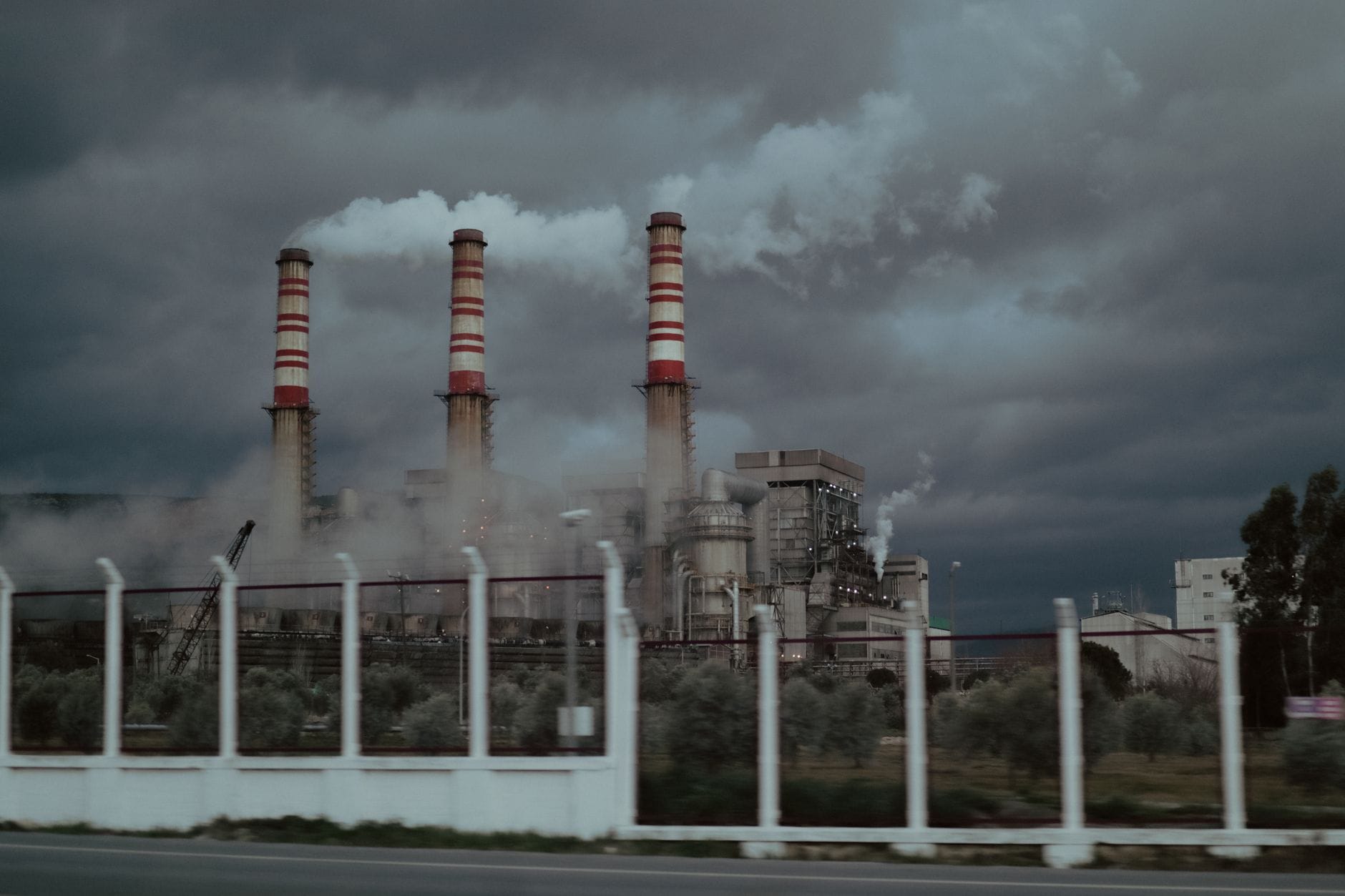 Dymiące kominy elektrowni na węgiel na tle burzowego nieba Dymiące kominy elektrowni na węgiel na tle burzowego nieba
