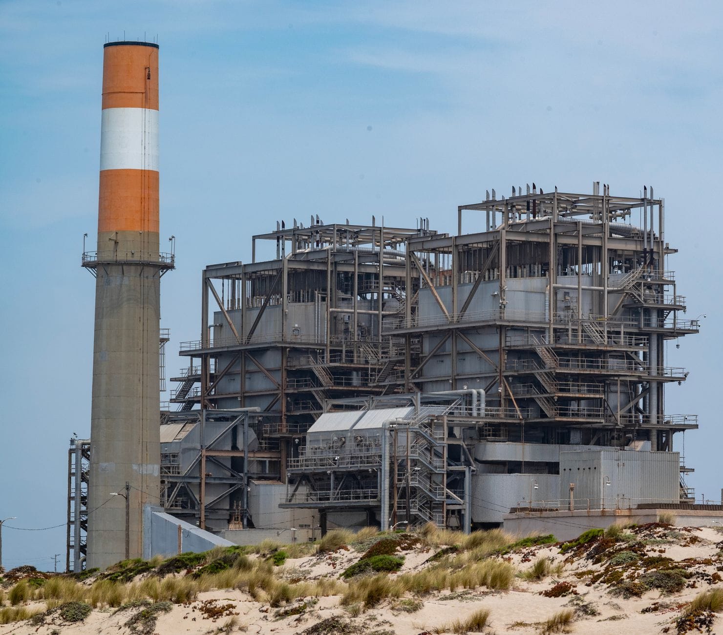 Gaz ziemny w elektroenergetyce: elastyczne moce bilansujące system z rosnącym udziałem wiatru i fotowoltaiki Elektrownia gazowa z kominem na piaszczystym wybrzeżu