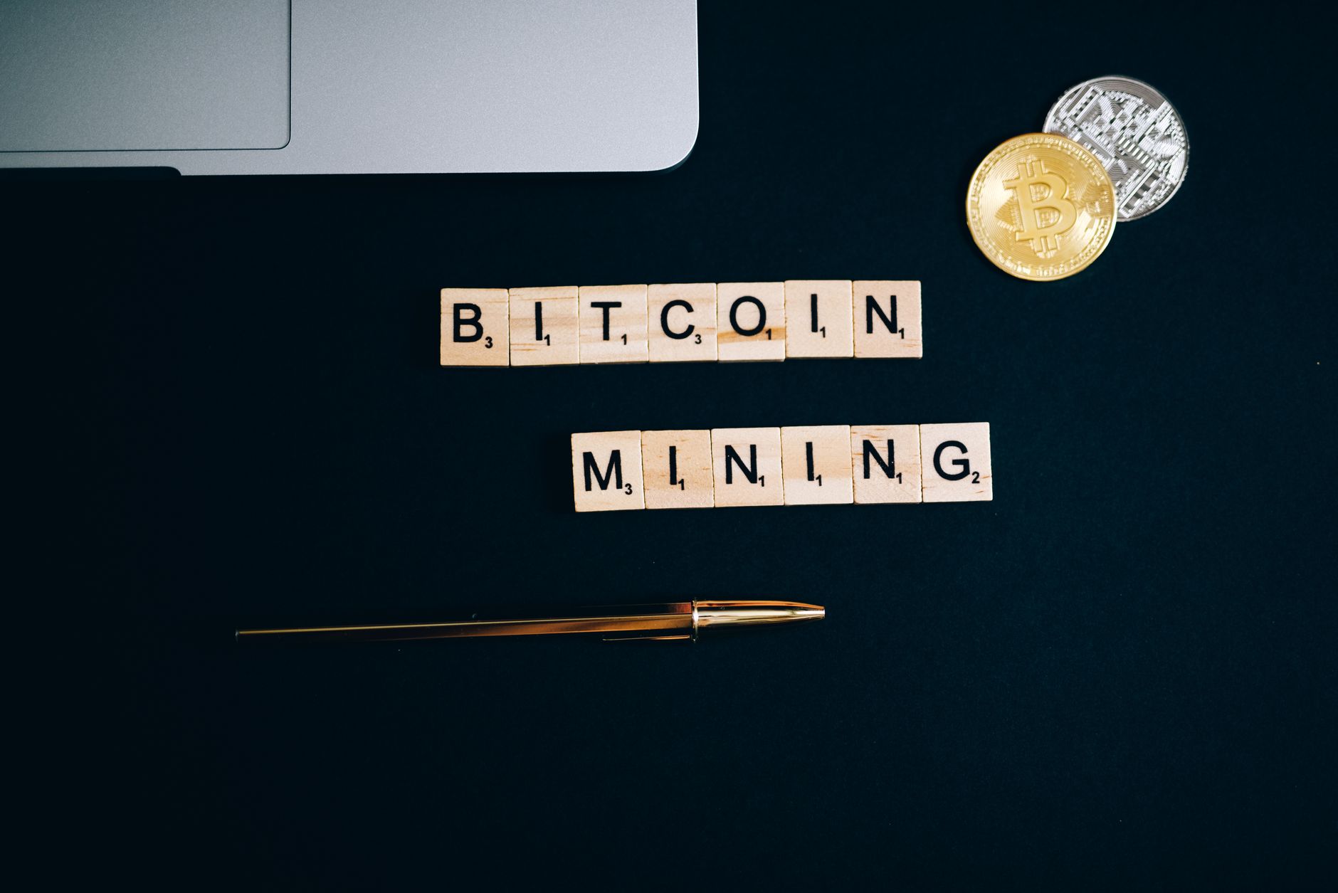 Jak cyfryzacja kopalń ogranicza koszty wydobycia i straty surowcowe Widok z góry na monety i litery układające napis Bitcoin na czarnym tle